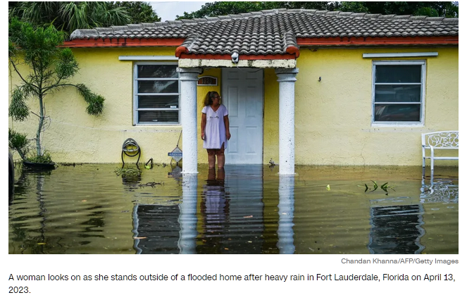 A woman looks on as she stands outside a flooded home after heavy rain in Fort Lauderdale, Florida April 13, 2023
